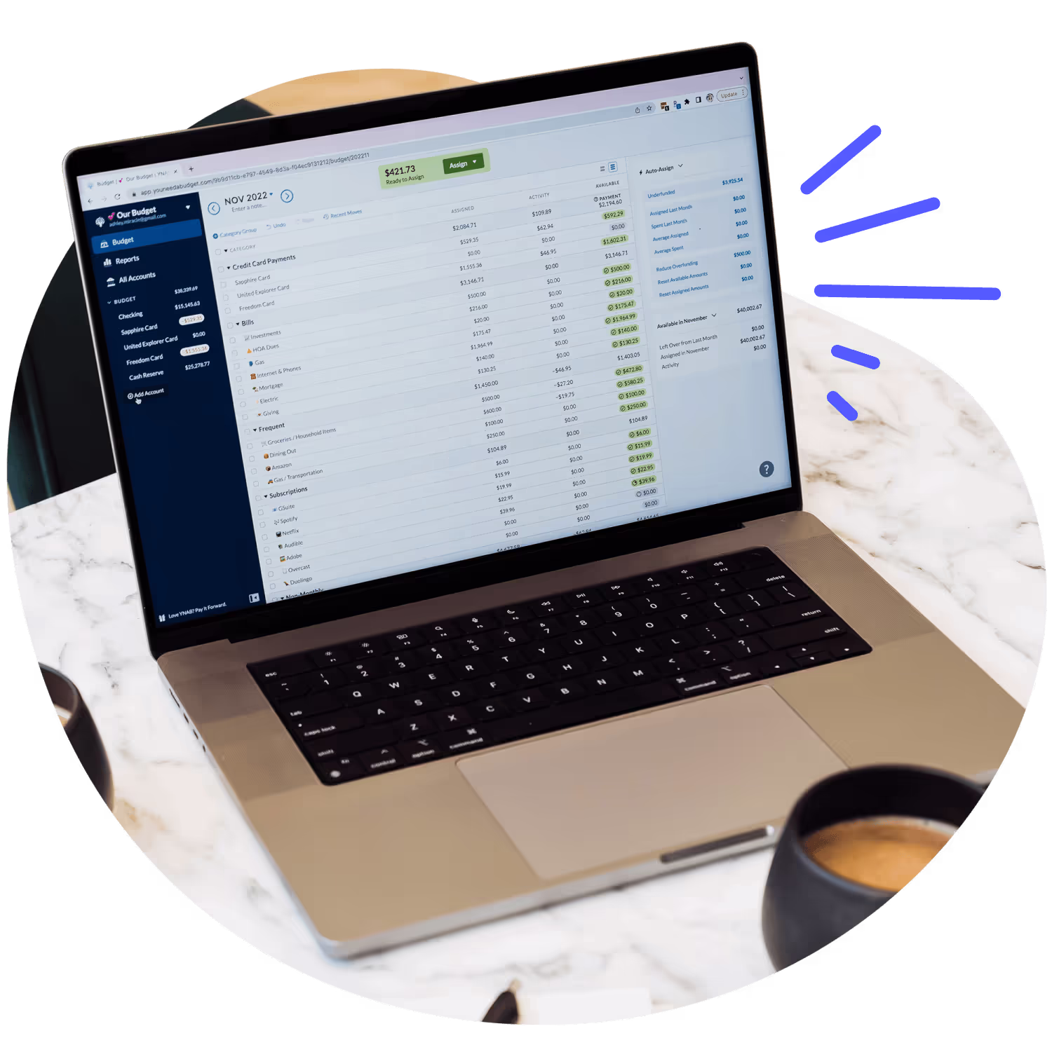 The YNAB web app shown on a laptop that's sitting on a counter with a mug of coffee